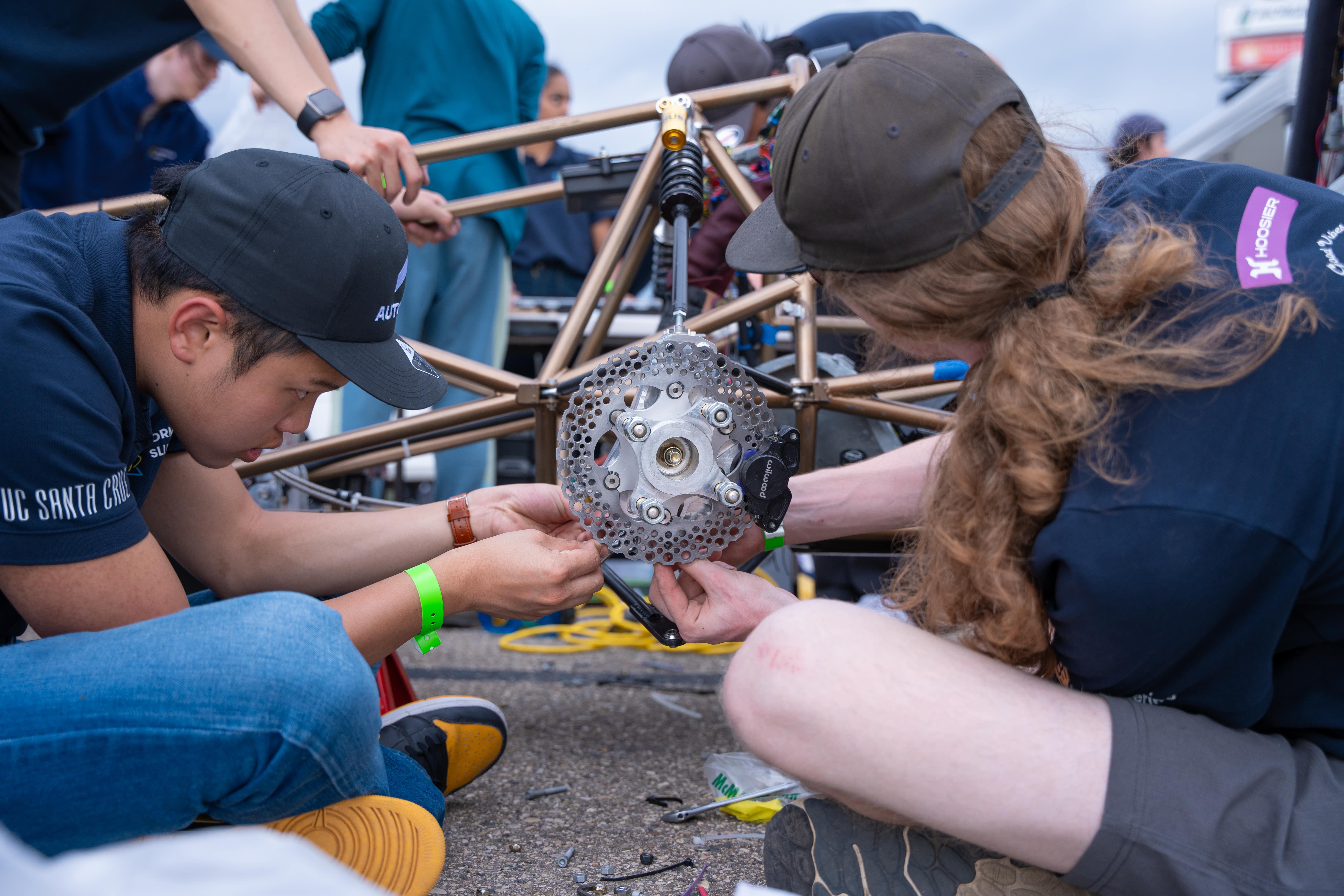 Two Mechanical Team Members Work on the Car