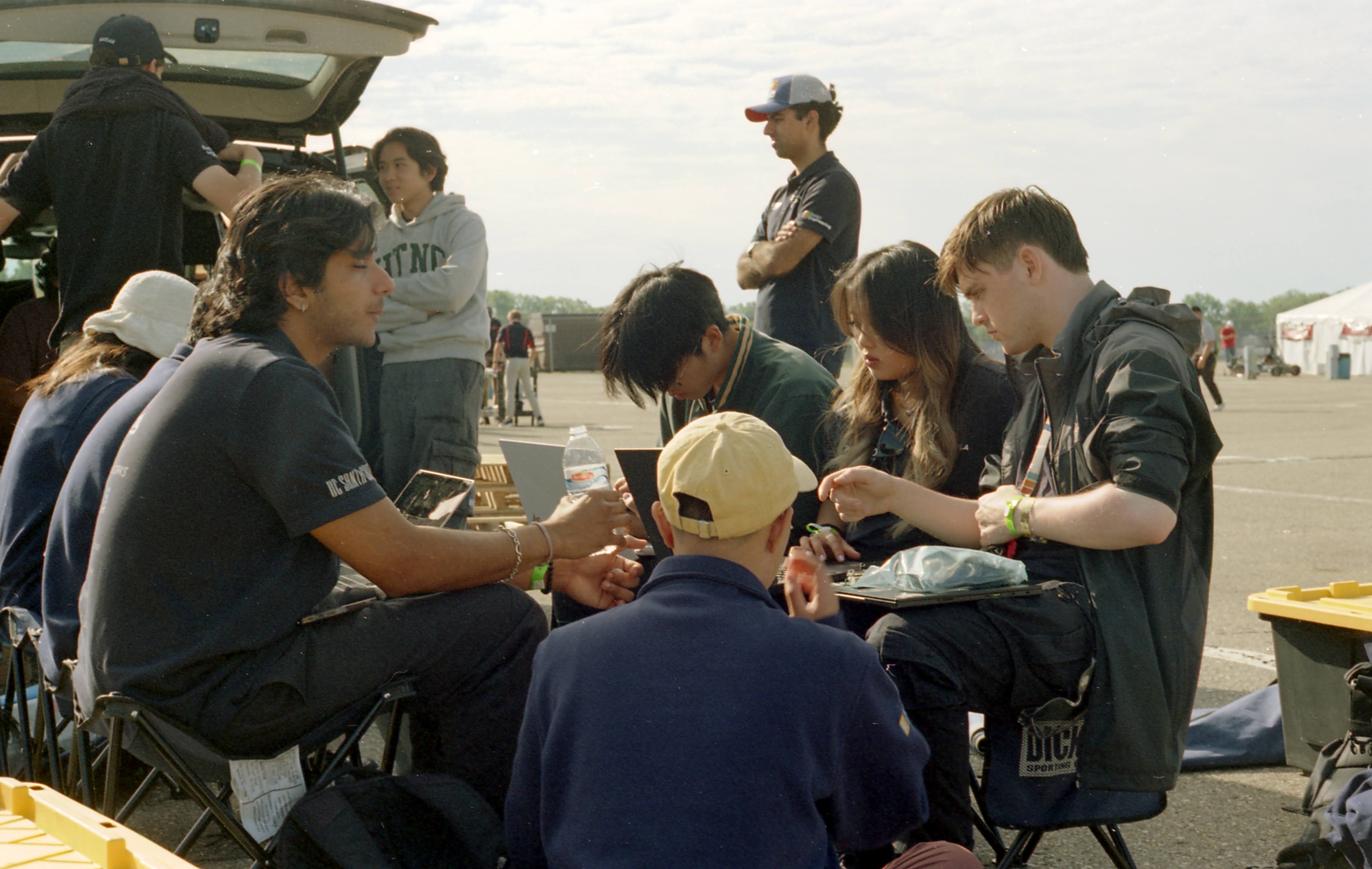 Team Members at Competition Taking a Break From Working on the Car